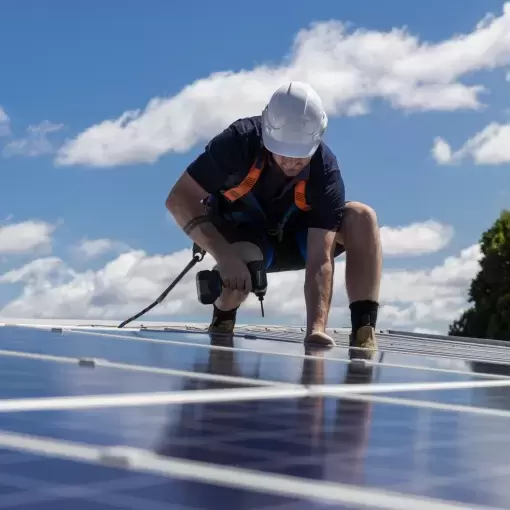 Contractor installing solar panels on roof of new house