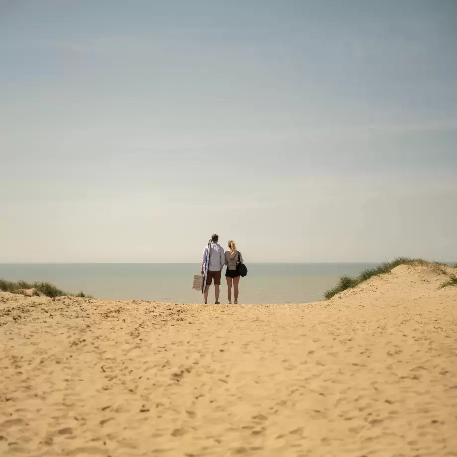 Couple standing on beach looking out to sea