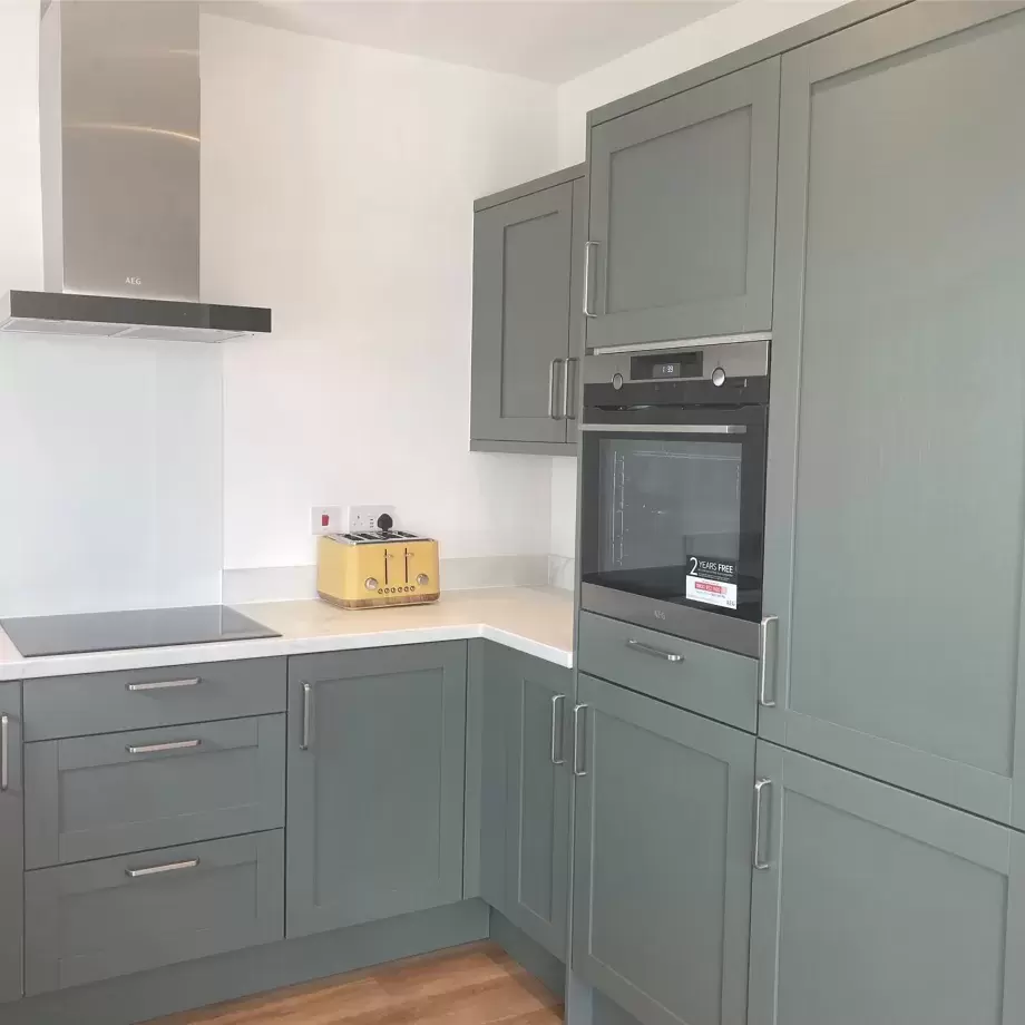 Shaker style wooden kitchen units painted sage green